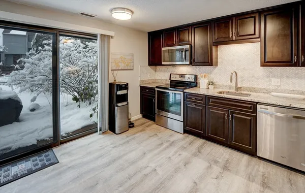 a kitchen with stainless steel appliances granite countertop a stove sink and cabinets