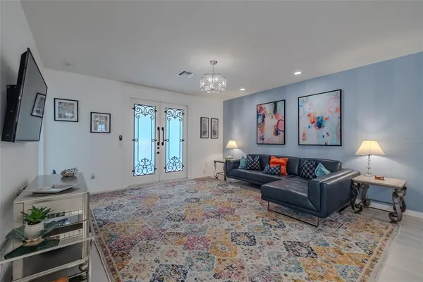 a view of a dining room and livingroom with furniture wooden floor a chandelier