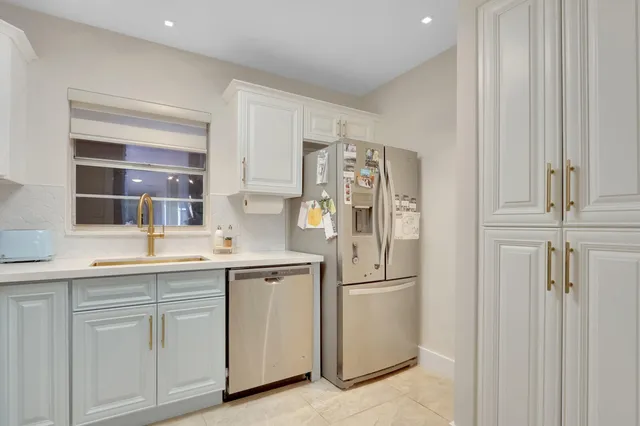 a kitchen with white cabinets and white appliances