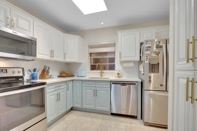 a kitchen with white cabinets and white appliances