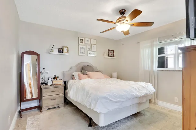 a bedroom with a large bed and ceiling fan