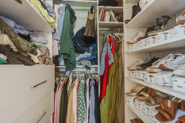 a view of walk in closet with clothes and shoes