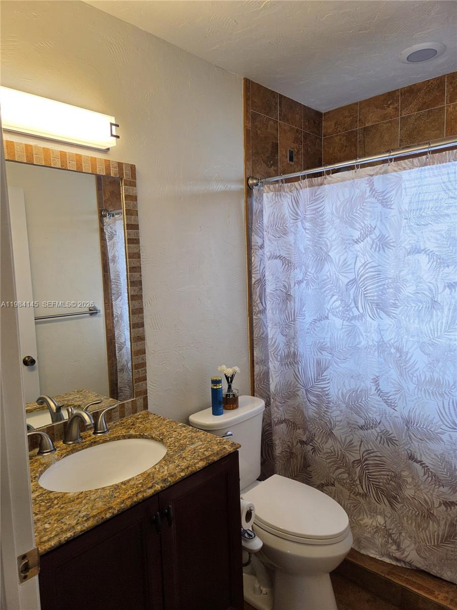 14365 Southwest 175th Terrace Miami, FL 33177 - Photo 13 of 31 a bathroom with a granite countertop sink toilet and shower