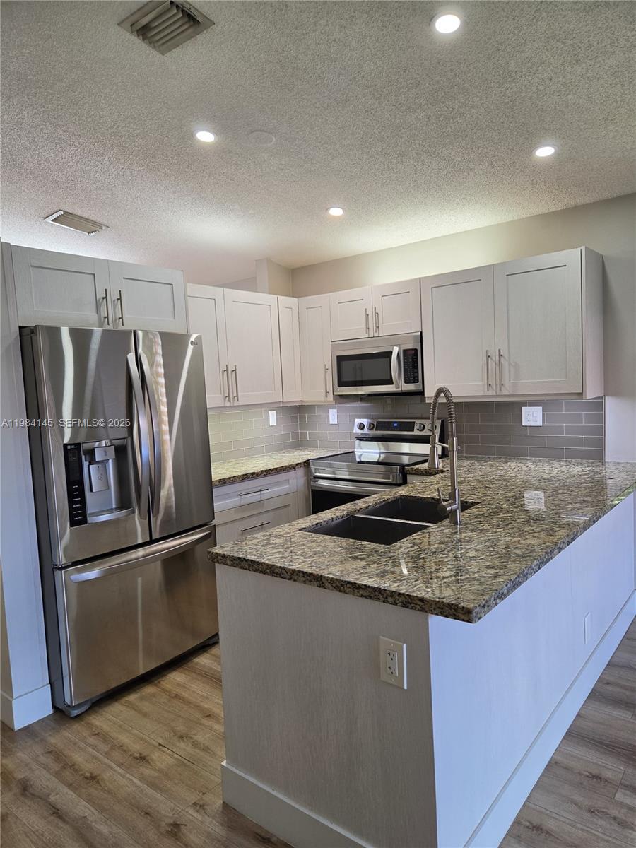14365 Southwest 175th Terrace Miami, FL 33177 - Photo 18 of 31 a kitchen with stainless steel appliances granite countertop a refrigerator a stove a sink and a microwave