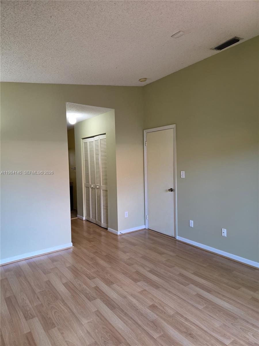 14365 Southwest 175th Terrace Miami, FL 33177 - Photo 25 of 31 a view of an empty room with wooden floor and a window