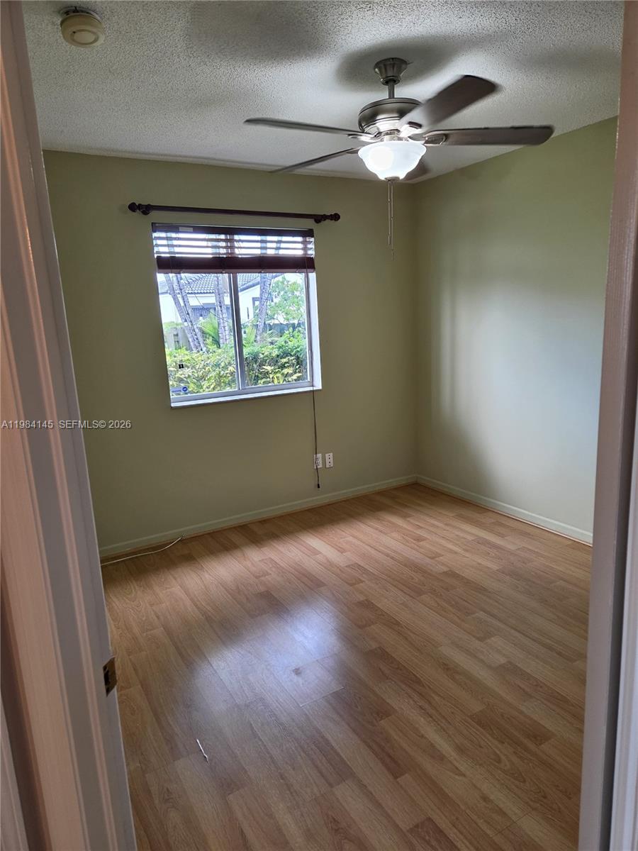 14365 Southwest 175th Terrace Miami, FL 33177 - Photo 8 of 31 en empty room with wooden floor and ceiling fan