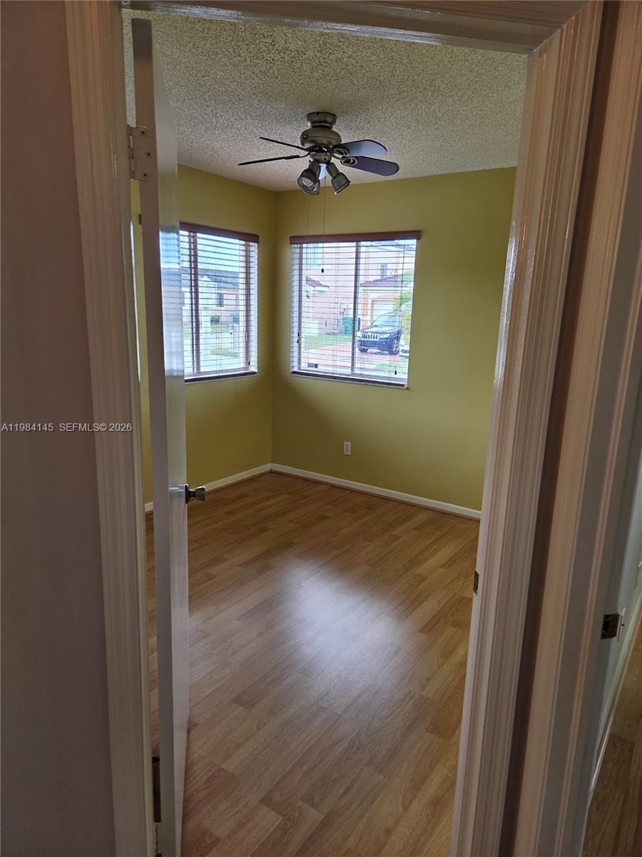 14365 Southwest 175th Terrace Miami, FL 33177 - Photo 10 of 31 an empty room with wooden floor chandelier and windows