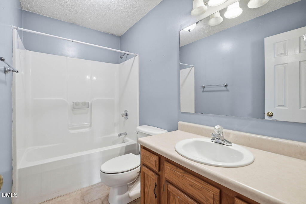 1560 Cane Mill Road Coats, NC 27521 - Photo 25 of 32 a bathroom with a sink a toilet and shower
