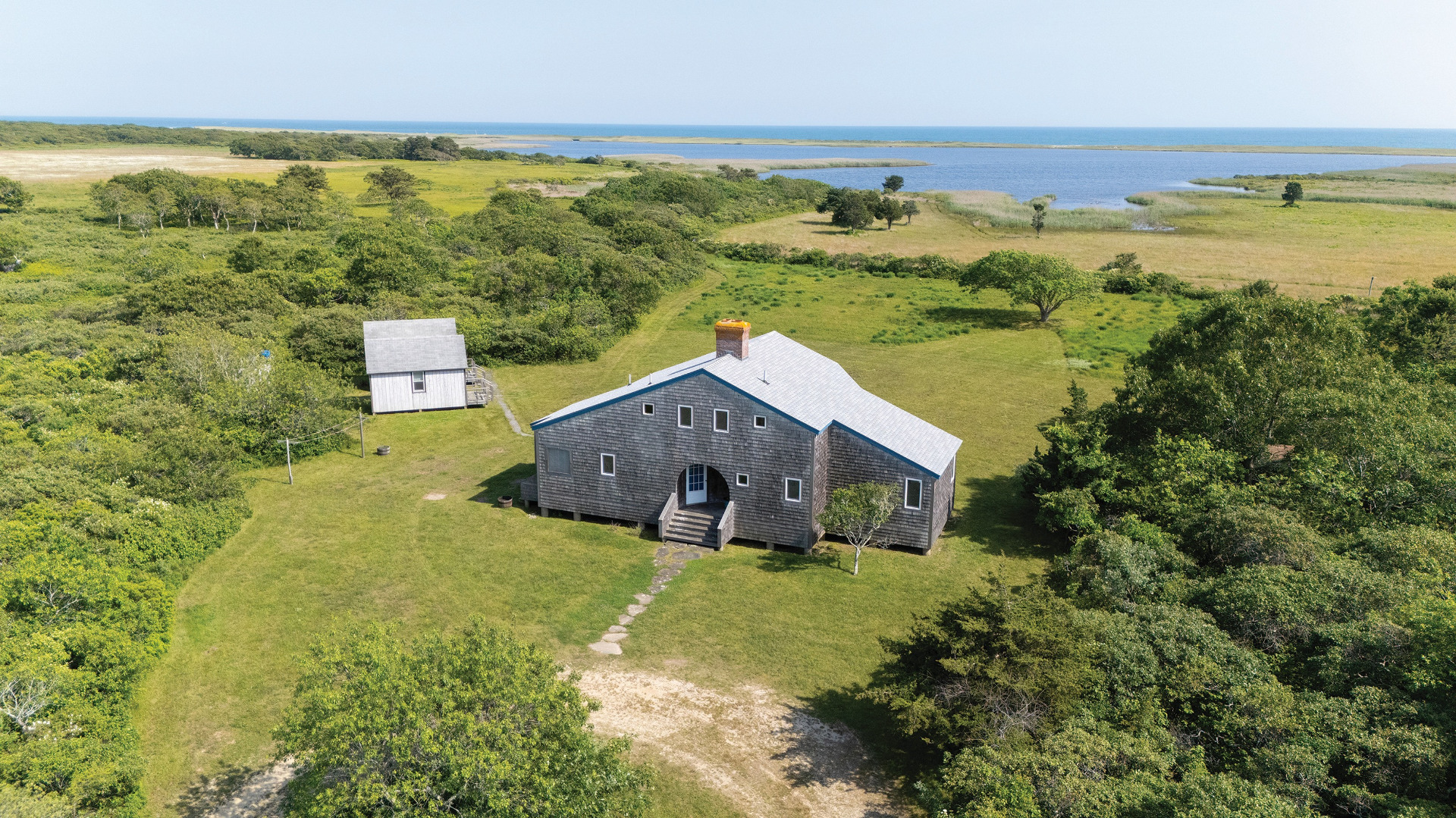 a aerial view of a house with a garden and lake view