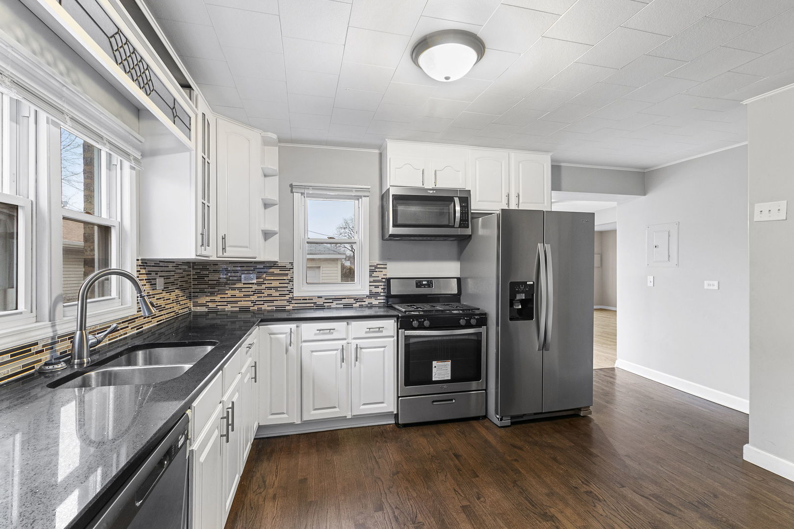 6837 Roberts Road Bridgeview, IL 60455 - Photo 3 of 22 a kitchen with stainless steel appliances granite countertop a refrigerator stove and sink