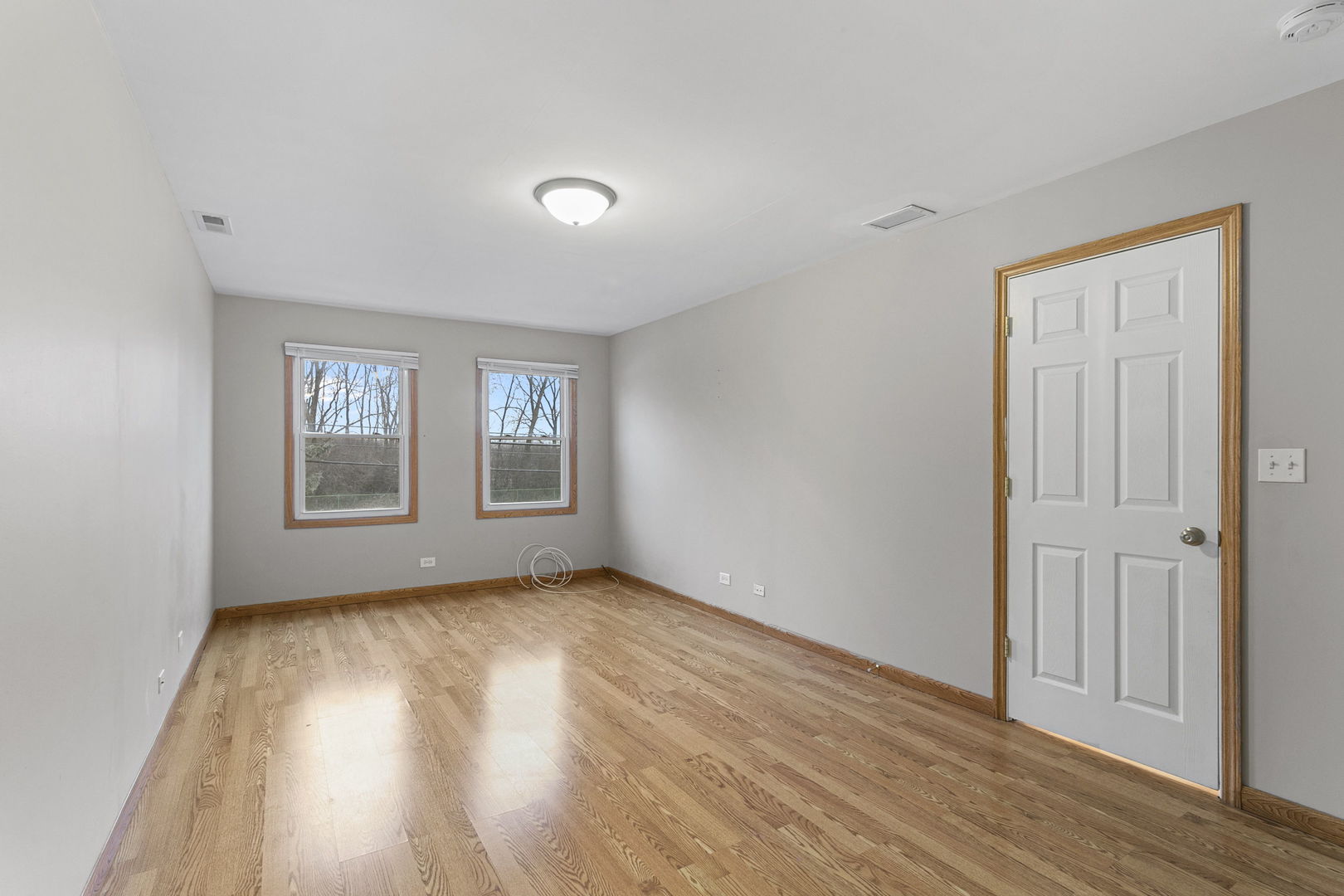 6837 Roberts Road Bridgeview, IL 60455 - Photo 9 of 22 an empty room with wooden floor and windows