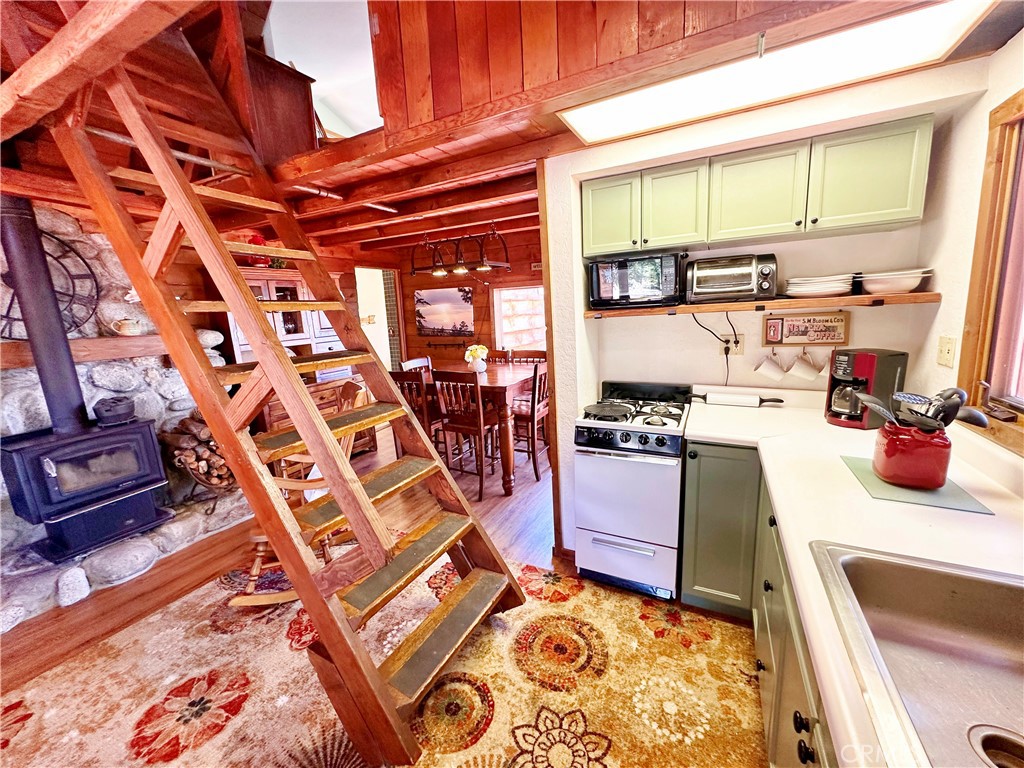 24387 Rocky Point Road Idyllwild, CA 92549 - Photo 6 of 29 a kitchen with stainless steel appliances granite countertop a stove and a wooden cabinets