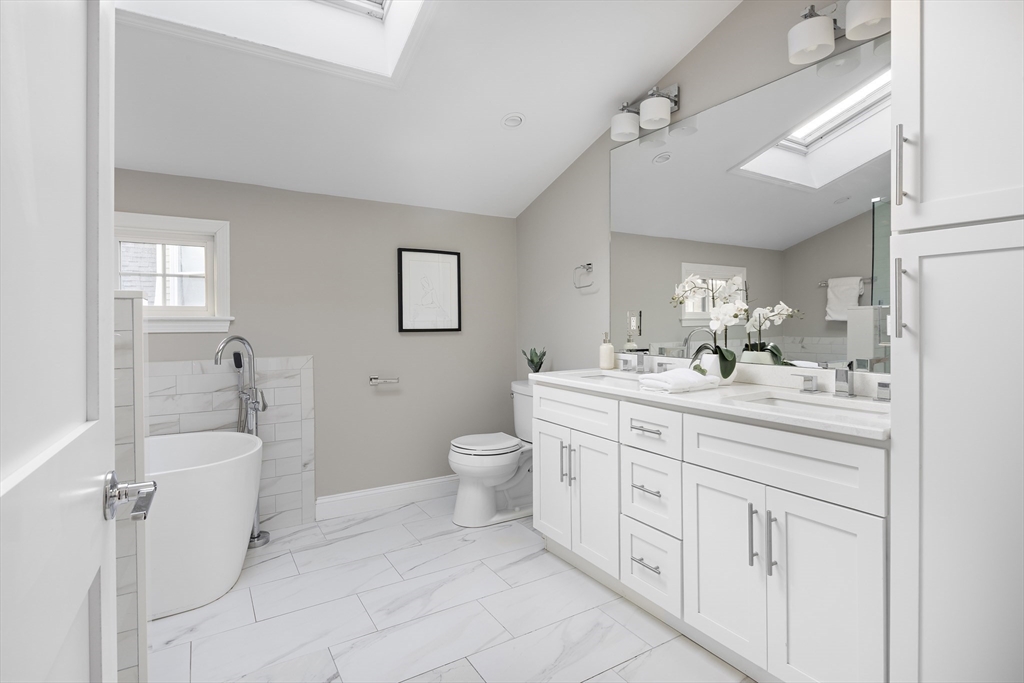 12 Madison Street, Unit 2 Somerville, MA 02143 - Photo 17 of 24 a spacious bathroom with a double vanity sink a mirror and a bathtub