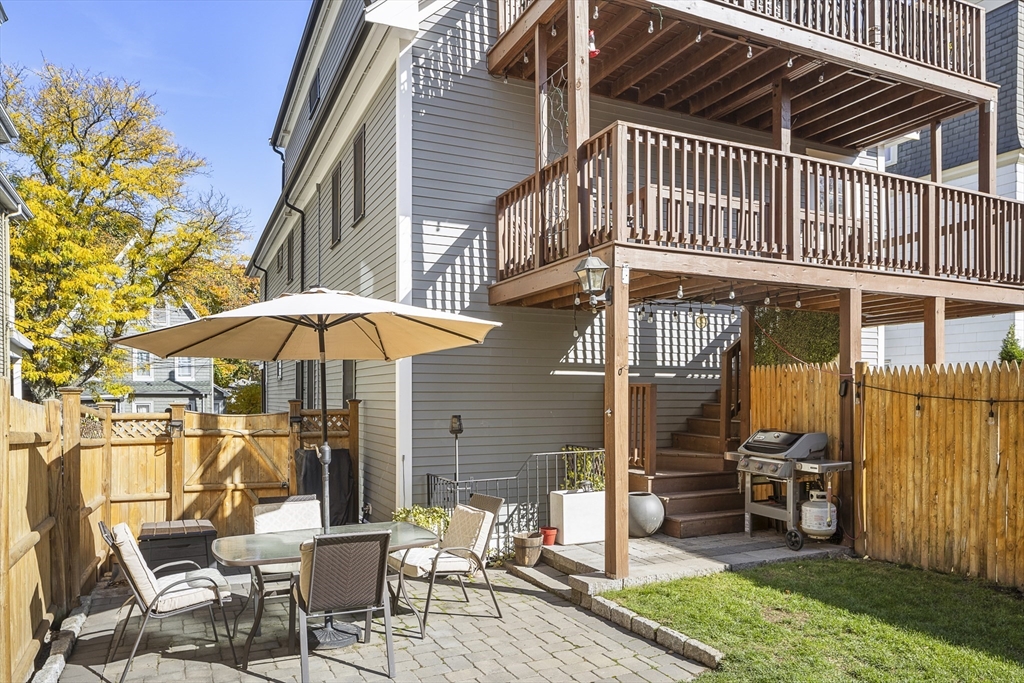 12 Madison Street, Unit 2 Somerville, MA 02143 - Photo 22 of 24 a patio with a table and chairs under an umbrella