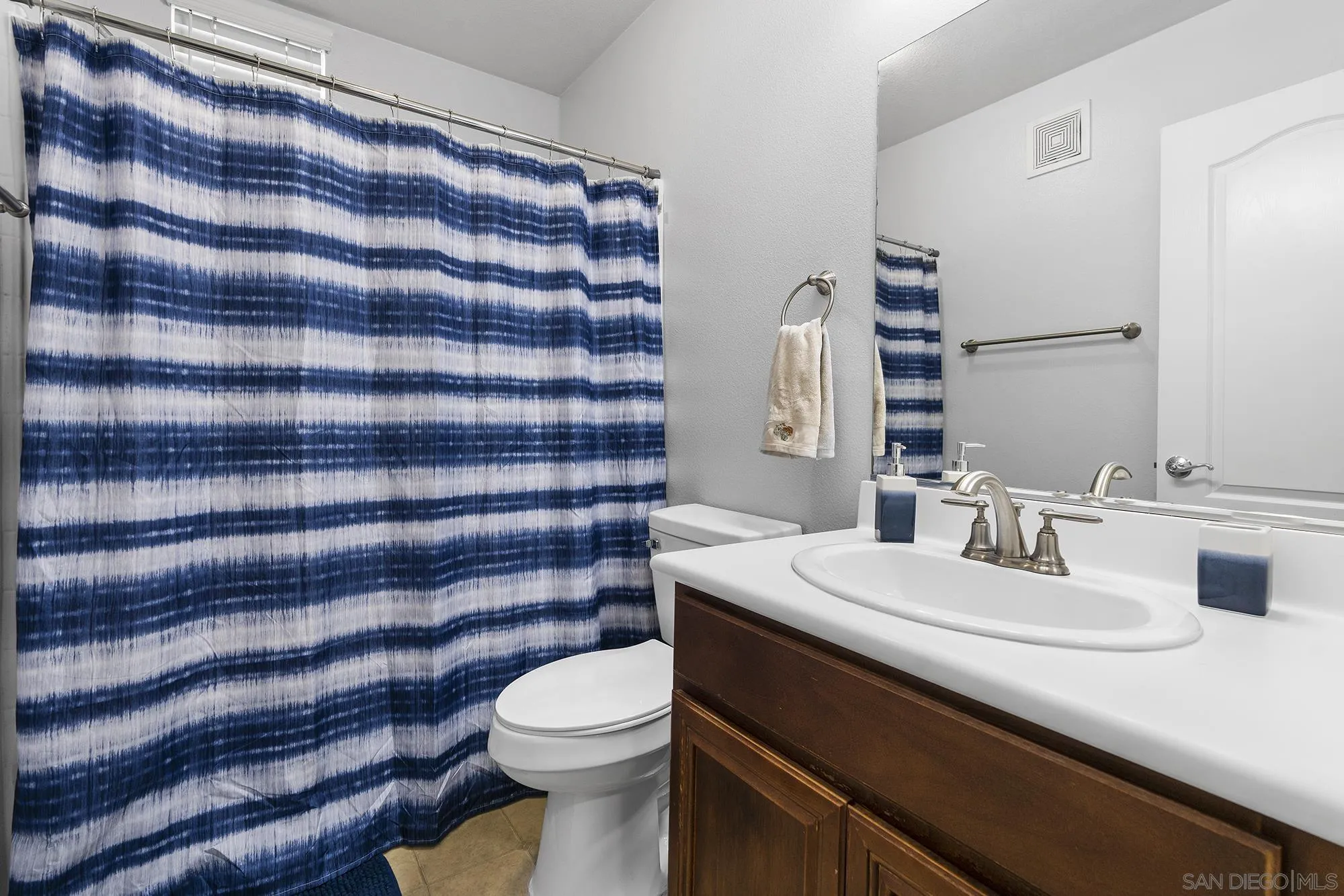 156 Via Montisi Santee, CA 92071 - Photo 16 of 25 a bathroom with a sink a toilet a mirror and shower curtain