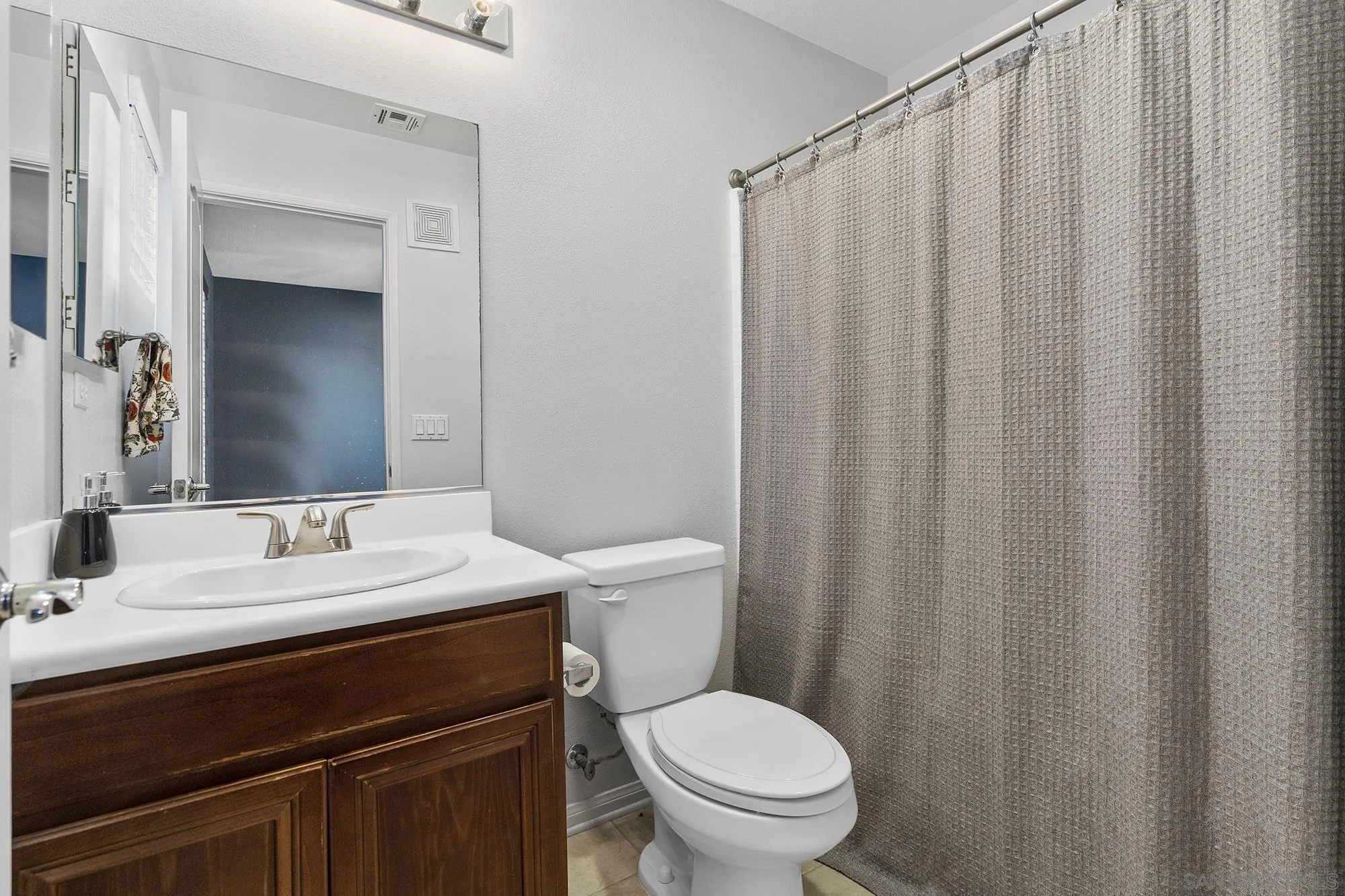 156 Via Montisi Santee, CA 92071 - Photo 20 of 25 a bathroom with a sink a toilet a mirror and shower curtain