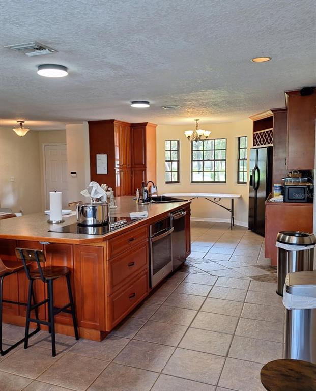 10012 Lake Louisa Road Clermont, FL 34711 - Photo 2 of 25 a large kitchen with kitchen island granite countertop a stove a sink and dishwasher wooden cabinets with granite countertops