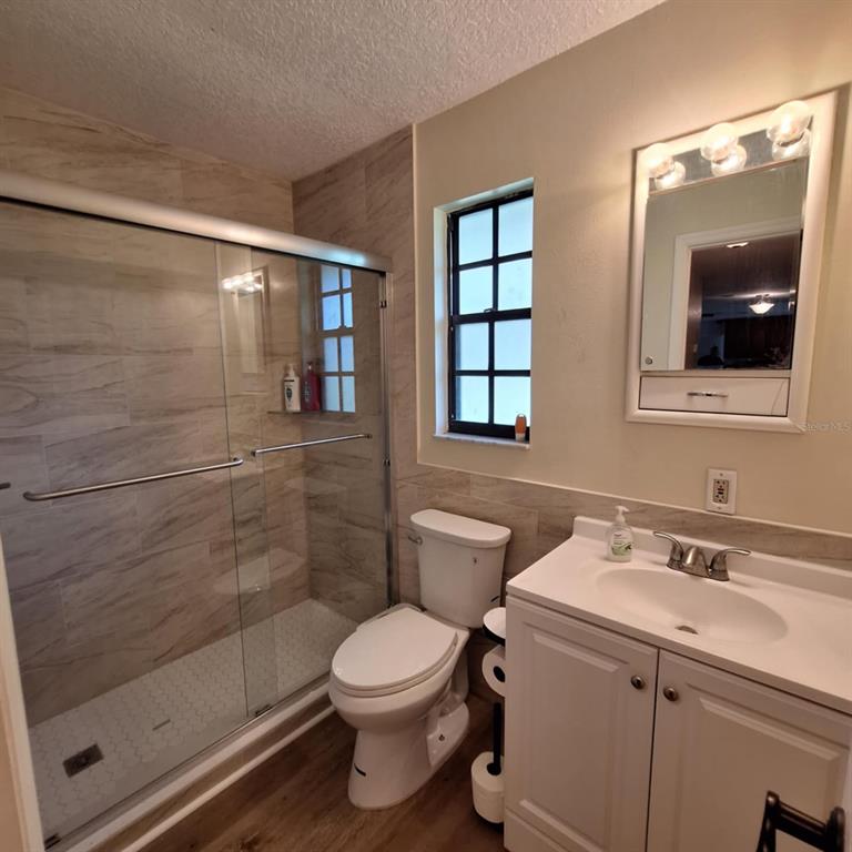 10012 Lake Louisa Road Clermont, FL 34711 - Photo 10 of 25 a bathroom with a toilet sink vanity and shower