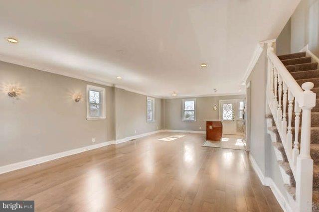 4621 Rokeby Road Baltimore, MD 21229 - Photo 8 of 28 a view of an empty room with wooden floor and stairs