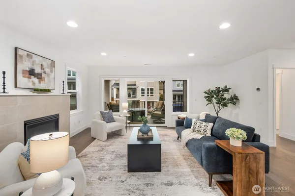 a living room with furniture large window and wooden floor