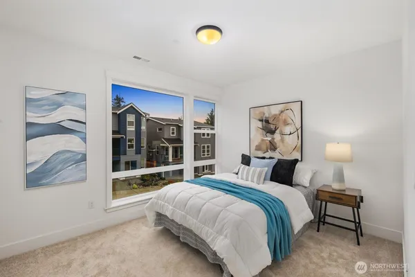a bedroom with a bed and a painting on the wall