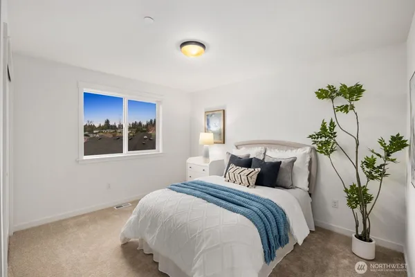 a bedroom with a bed and a potted plant