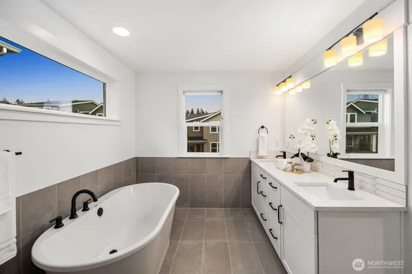 a bathroom with a double vanity sink a mirror and a bathtub