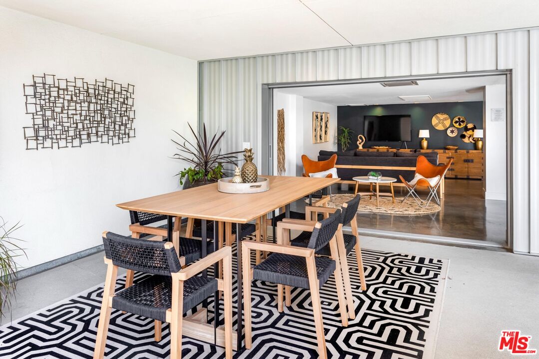12760 Millennium Drive, Unit NB107 Los Angeles, CA 90094 - Photo 22 of 38 a view of a dining room with furniture wooden floor and a chandelier