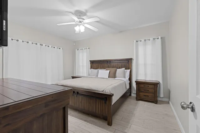 a spacious bedroom with a bed and a flat screen tv