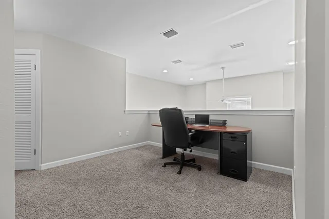 a view of a workspace with furniture and a window