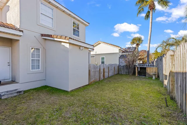 a view of a swimming pool with a chair and palm trees