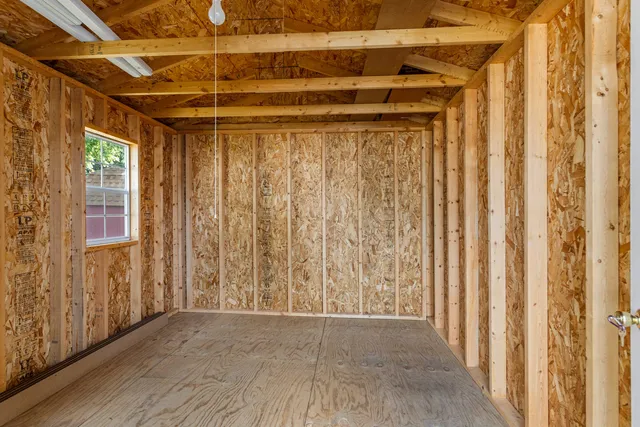 a view of a room with wooden walls and a window