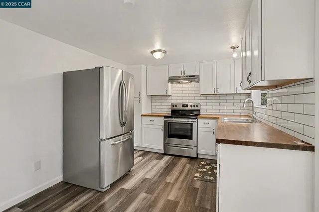 a kitchen with a refrigerator stove and white cabinets