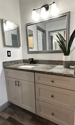 a bathroom with a granite countertop double vanity sink and mirror