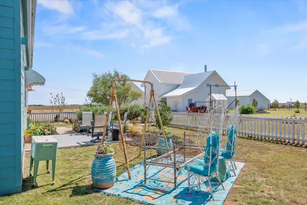 a view of a house with a small yard and a large tree