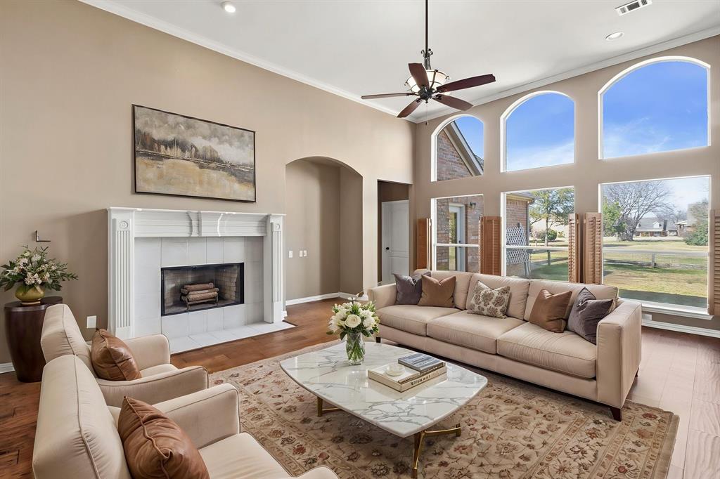 7517 Rodeo Drive Denton, TX 76208 - Photo 2 of 39 Main living room virtually staged - features a fireplace and a wall of windows with abundant natural light!