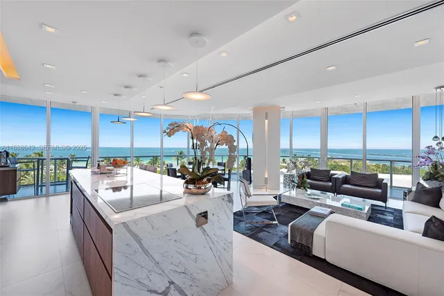 a living room with furniture kitchen and a large window