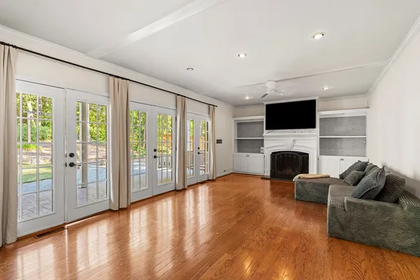 a view of empty room with wooden floor and fan
