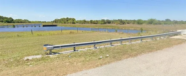 a view of a swimming pool with a yard and plants