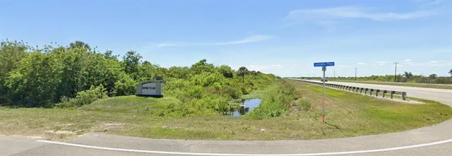 a sign that is sitting in front of a tree