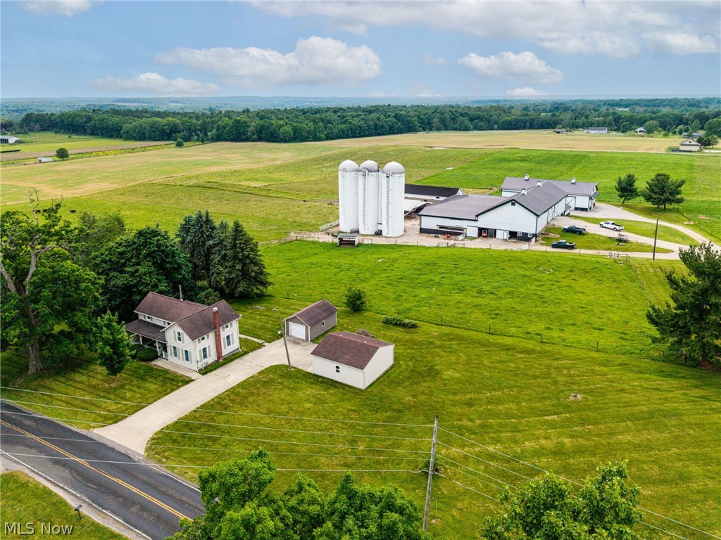 9626 Daniels Road Seville, OH 44273 - Photo 3 of 37 Expansive rural property featuring a traditional two-story home, a multi-structure farm compound with silos, a detached garage, and an additional outbuilding, all set on extensive green acreage
