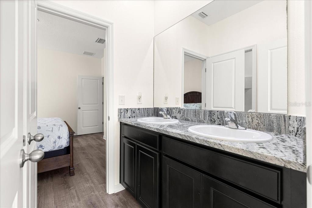 5851 Southwest 85th Place Ocala, FL 34476 - Photo 31 of 57 a en suite bathroom with a granite countertop sink and a mirror