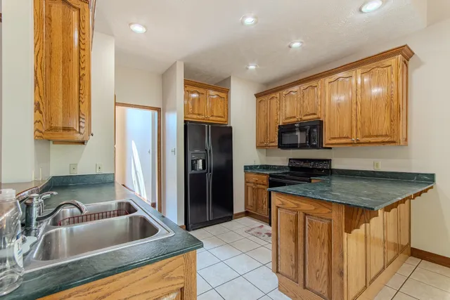 a kitchen with stainless steel appliances granite countertop a sink refrigerator and microwave