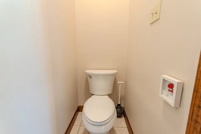 a white toilet sitting next to a white wall