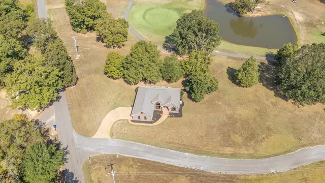 an aerial view of a house with a yard and lake view