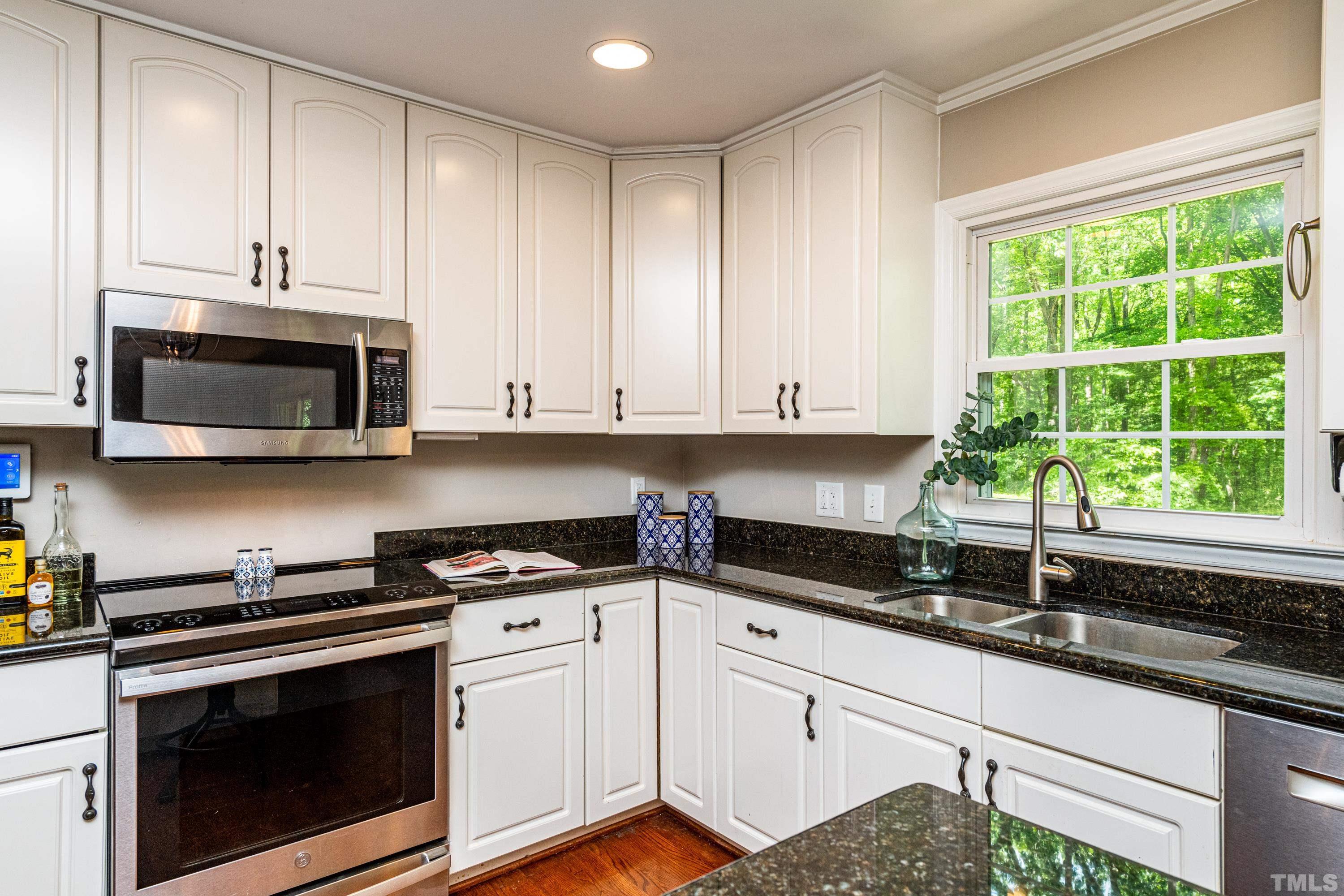 201 Chatterson Drive Raleigh, NC 27615 - Photo 9 of 44 a kitchen with granite countertop white cabinets stainless steel appliances and a sink
