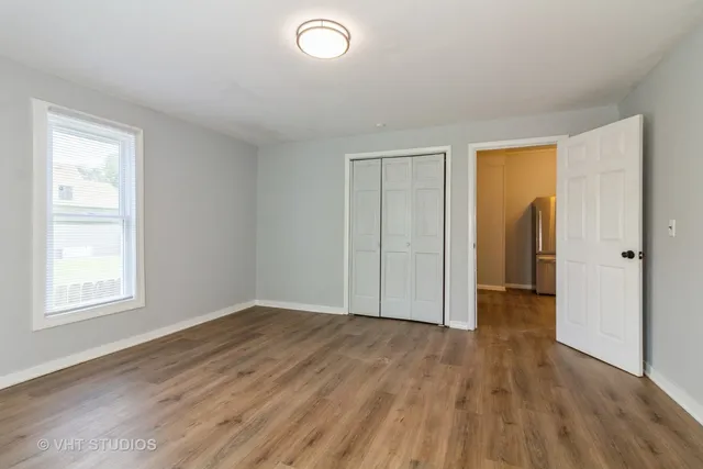 an empty room with wooden floor and closet