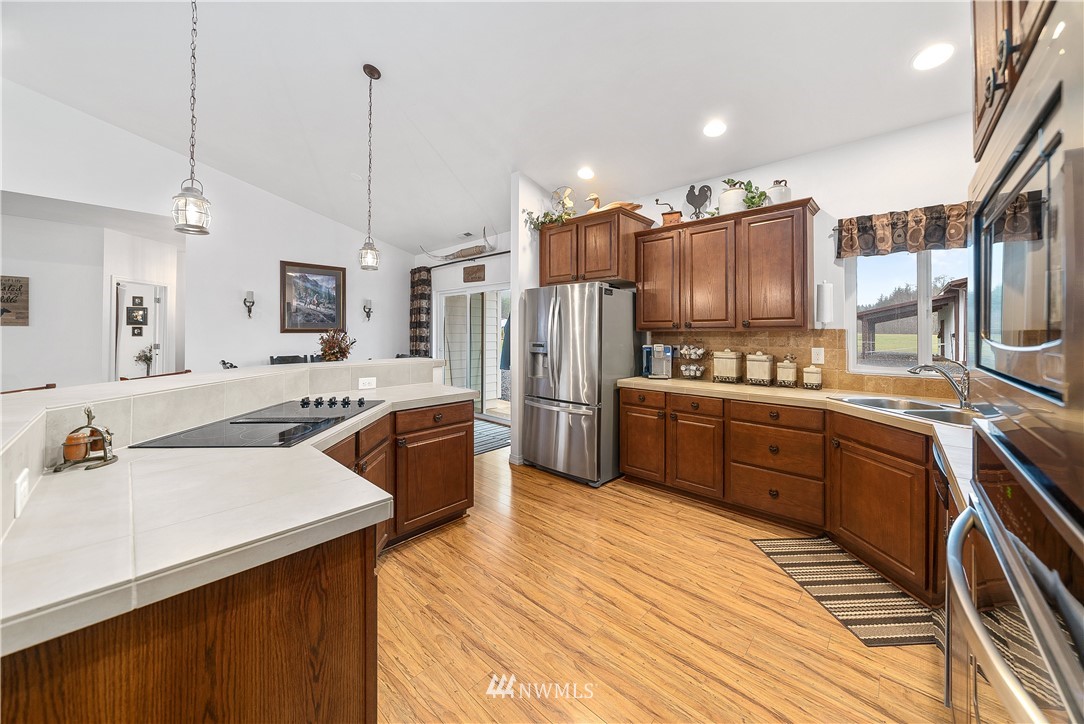 316 Pleasant Hill Road Chehalis, WA 98532 - Photo 8 of 30 a kitchen with stainless steel appliances a stove a sink dishwasher a refrigerator with white cabinets and wooden floor