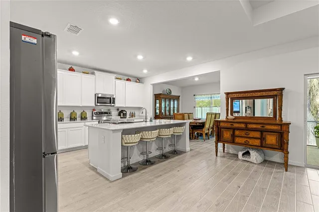 a open kitchen with stainless steel appliances granite countertop a refrigerator and a stove top oven