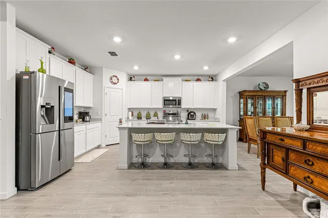 a kitchen with stainless steel appliances a refrigerator and a stove top oven